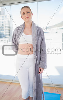 Serious sporty blonde wearing a bathing gown