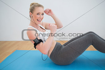 Laughing sporty blonde listening to music and exercising