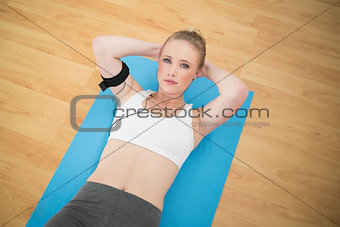 Content sporty blonde listening to music and exercising
