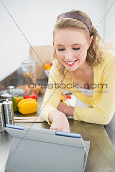 Smiling cute blonde looking at tablet