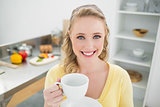 Smiling cute blonde holding a cup