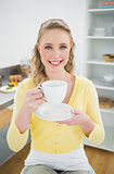 Cheerful cute blonde holding a cup