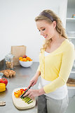 Happy cute blonde chopping vegetables