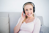 Casual smiling blonde listening to music