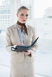 Blonde attractive businesswoman holding a diary