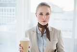 Blonde content businesswoman holding disposable cup