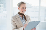 Blonde smiling businesswoman holding clipboard