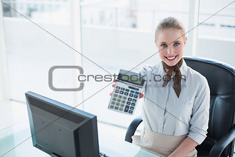 Blonde smiling businesswoman showing calculator