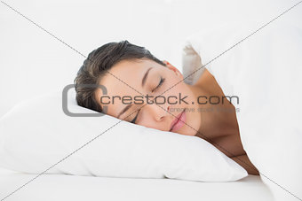 Pretty casual brunette sleeping in her bed