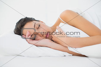 Sleepy casual brunette lying in her bed