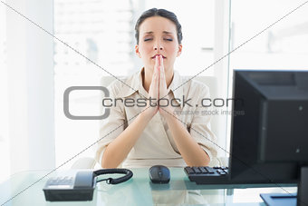 Anxious stylish brunette businesswoman praying