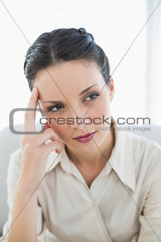 Thinking stylish brunette businesswoman posing looking away