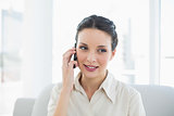 Pleased stylish brunette businesswoman making a phone call
