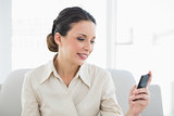 Content stylish brunette businesswoman looking at her mobile phone