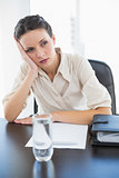 Irritated stylish brunette businesswoman holding her head and looking away
