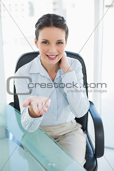Pleased stylish brunette businesswoman presenting her hand