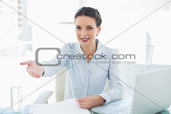 Cheerful stylish brunette businesswoman presenting her hand