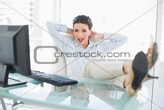 Pleased stylish brunette businesswoman relaxing with feet up