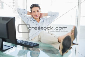 Content stylish brunette businesswoman relaxing with feet up