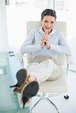 Happy stylish brunette businesswoman relaxing with feet up