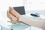 Close up of a businesswoman in high heels relaxing with feet up