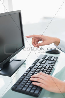 Close up of a businesswoman pointing to her computer screen with her finger