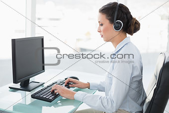 Concentrated stylish brunette operator using a computer