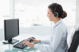 Smiling stylish brunette operator using a computer