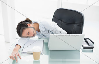 Exhausted stylish brunette businesswoman sleeping on her desk
