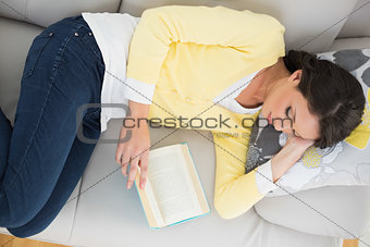 Relaxed casual brunette in yellow cardigan reading a book