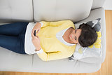 Peaceful casual brunette in yellow cardigan using a mobile phone