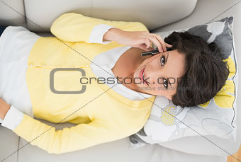 Pretty casual brunette in yellow cardigan making a phone call