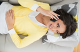Joyful casual brunette in yellow cardigan making a phone call