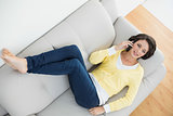 Attractive casual brunette in yellow cardigan making a phone call