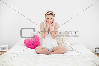 Smiling woman sitting on her bed