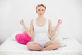 Smiling young woman meditating with closed eyes