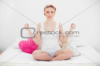 Smiling young woman meditating with closed eyes