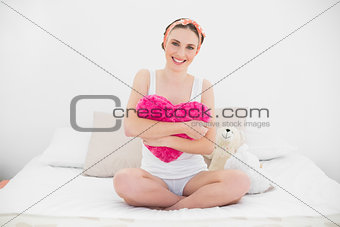 Smiling young woman holding her pillow