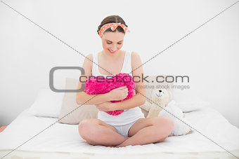 Young woman holding her pillow looking down