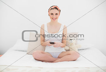 Smiling young woman holding her smartphone