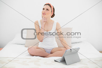 Thinking woman working with her tablet
