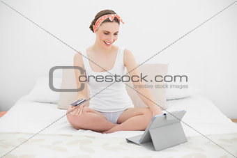 Smiling woman using her tablet looking down