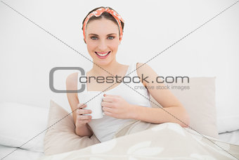 Pretty woman holding a cup looking into the camera