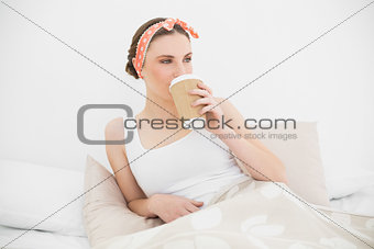 Young woman drinking a coffee in her bed