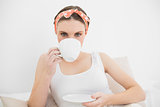 Woman drinking a cup of tea looking into the camera