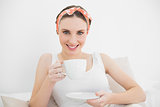 Woman smiling into camera holding a cup of tea