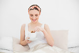Smiling woman dipping a biscuit into her coffee