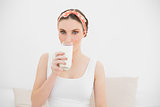 Woman drinking a glass of milk looking into the camera