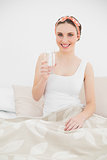 Smiling woman holding a glass of water looking into the camera