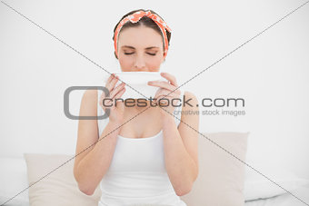 Young woman sneezing into a handkerchief